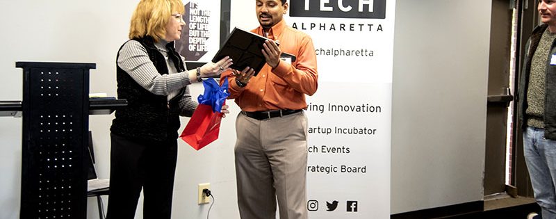 Karen Cashion gives a certificate for recognition to Adwait Joshi from DataSeers at the Tech Alpharetta Graduation